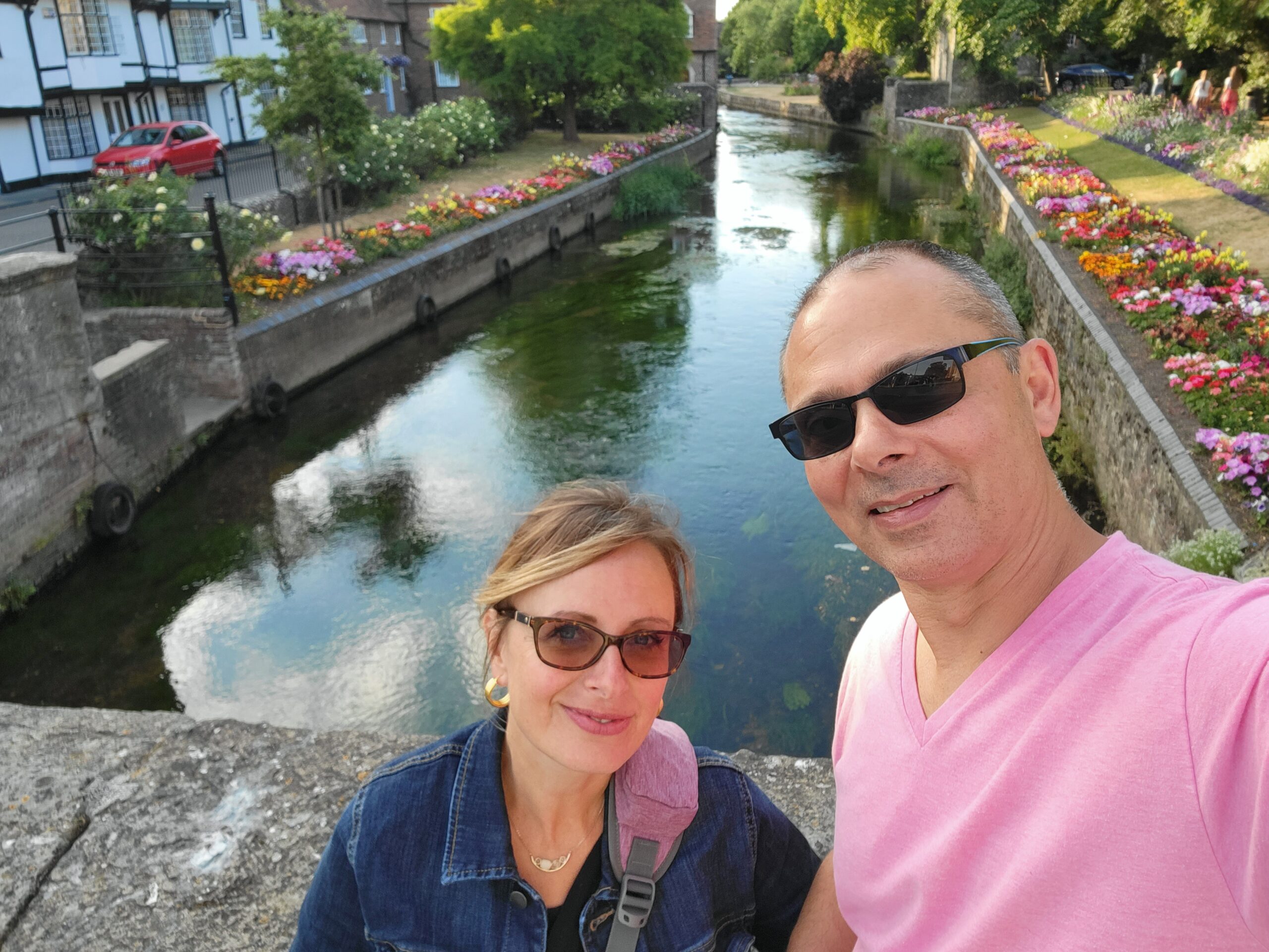 A man and woman standing next to each other near water.